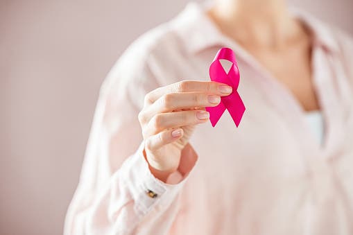 Woman holding pink breast cancer ribbon