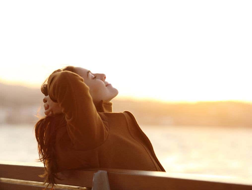 Woman relaxing on a bench in winter on the beach