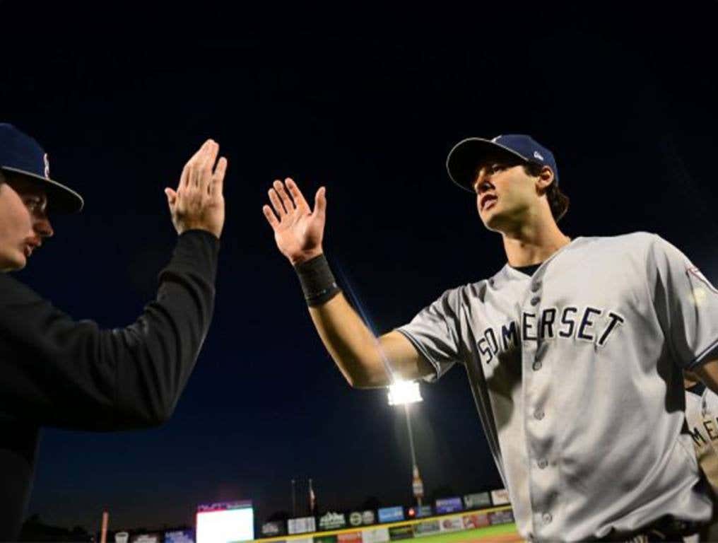 Spencer Jones high fives teammates in the Somerset dugout.