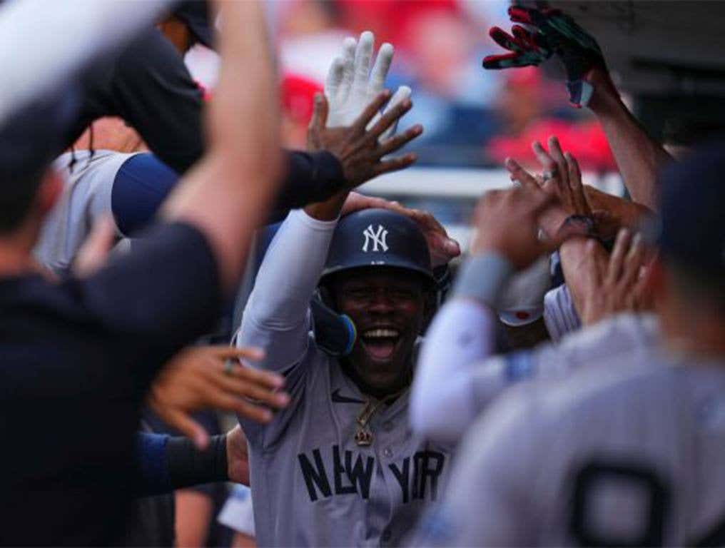 Jazz Chisholm celebrates a home run in the Yankees dugout.