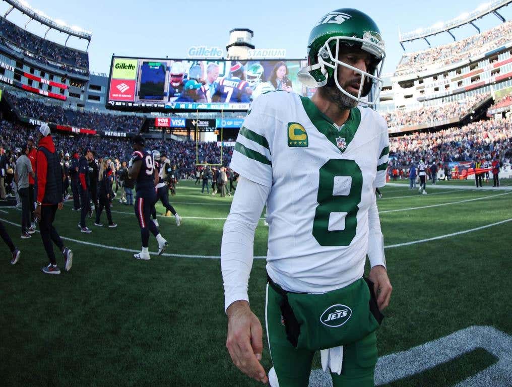 Aaron Rodgers walks off the field dejected.