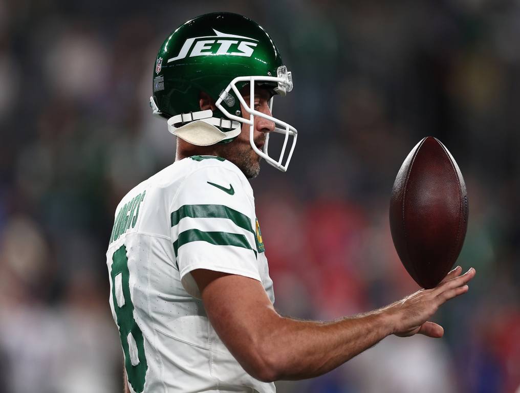 Aaron Rodgers plays with a football. 